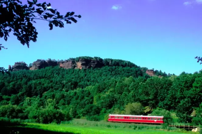Die Wieslauterbahn gehört zu den schönsten Bahnstrecken der Pfalz. Das Foto zeigt einen Zug vor dem Hochstein bei Dahn.