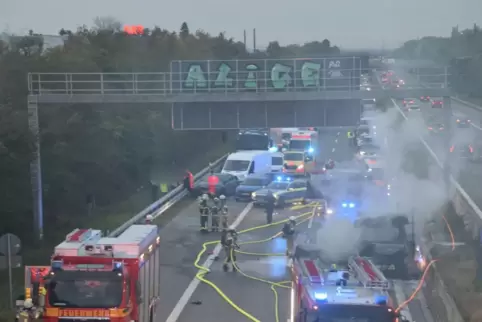 Zahlreiche Einsatzkräfte der Feuerwehr versuchen, das brennende Fahrzeug zu löschen.
