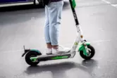 Person mit hochgekrempelter Hose auf E-Scooter (Detail)