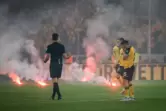Ausrastende Zuschauer, Feuer auf dem Rasen, leidende Spieler: eine Szene aus dem Relegationsrückspiel 2022 zwischen Dynamo Dresd