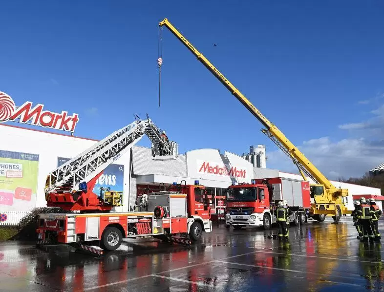 Das THW zerschneidet die Metallblende am Media Markt, bevor sie weg fliegen kann.