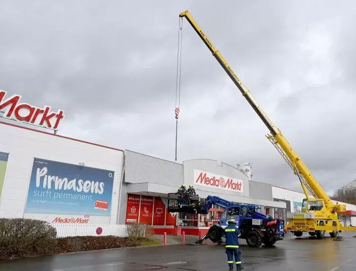 Das THW zerschneidet die Metallblende am Media Markt, bevor sie weg fliegen kann.