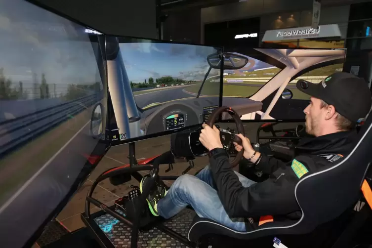 Beim Simracing fährt man mit einem Lenkrad und Pedalen in Rennschalensitzen vor einem Monitor.