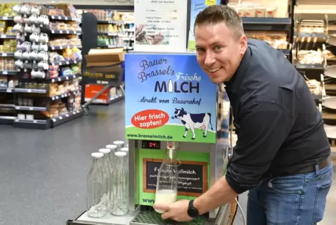 Marktleiter Sven Stiegler beim Milchzapfen. 