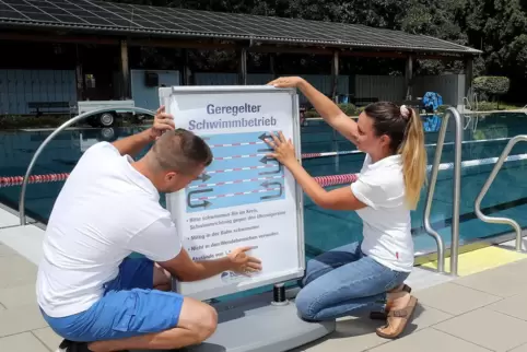 „Geregelter Schwimmbetrieb“: So heißt die Vorgabe, die Kevin Zimmermann und Annalena Brönner (von links) am Becken bekanntmachen