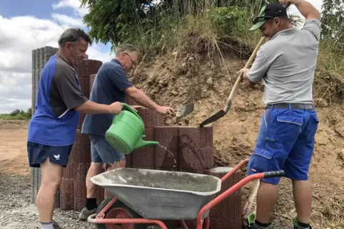 Oswald Alleborn, Bernd Findt und Petru Alin Farchescu betonieren die Einfahrt zum neuen Grüngut-Sammelplatz in Ebertsheim.