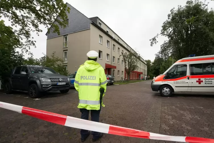 Polizeibeamte stehen vor einem Studentenwohnheim. In drei Studentenwohnheimen sind Bewohner an Covid-19 erkrankt, andere zeigen 