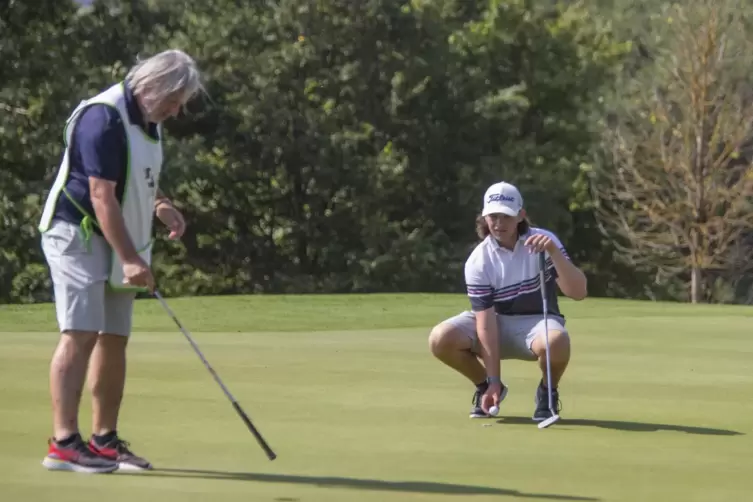 Lenny Koch aus Österreich bespricht mit seinem Vater und Caddy Walter die beste Linie für den Putt.