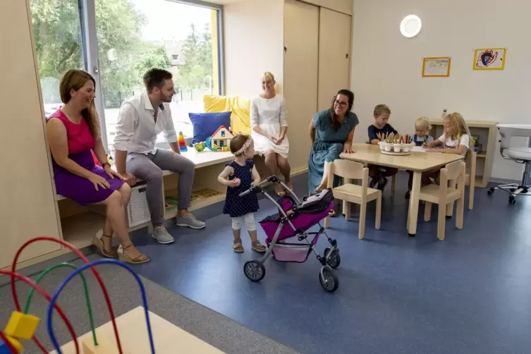 Melanie, Daniel und Tochter Marleen Mergler (von links) werden wie die anderen Eltern und Kinder durch die neue Kita geführt. Ti