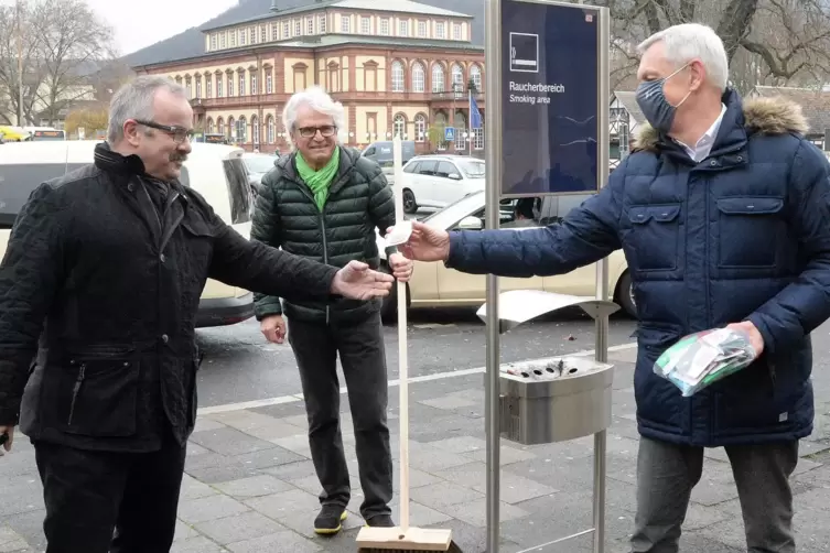 Ulrich Demmer (r.) und Norbert Schied übergeben Kippendöschen und Besen an Yavuz Yildirim. 