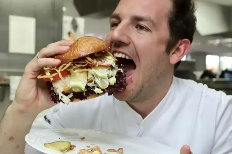 Und rein damit: Krone-Chefkoch Fabio Daneluzzi genießt seinen Saumagenburger.