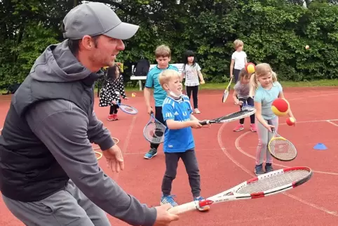 Mit dem Tennisschläger den Ball in der Luft halten: Rares Georgescu übt mit den kleinsten Tennisspielern.