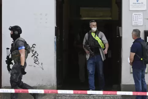 Polizisten gehen aus einem Gebäude in der Belhradska Straße im Prager Stadtteil Vinohrady. 