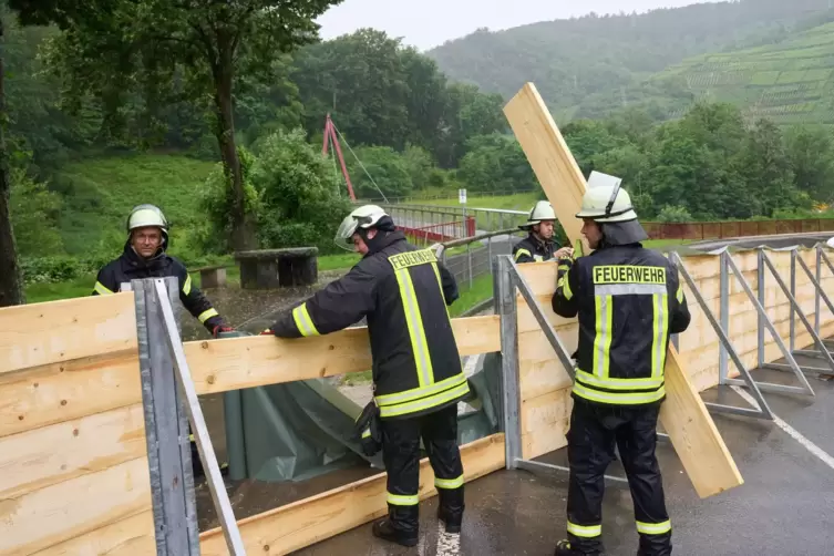 Feuerwehrleute errichten im Ahrtal bei Mayschoss eine Sperrwand aus Holz. 