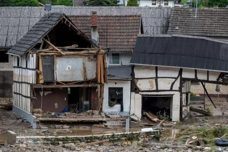  Schutt liegt in Schuld im Kreis Ahrweiler nach dem Hochwasser vor einem beschädigten Gebäude.