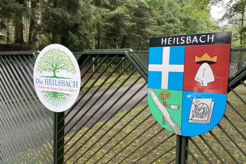 Das neue Logo (links) und das alte Wappen der Heilsbach hängen an der Zufahrt zu dem weitläufigen Gelände. 