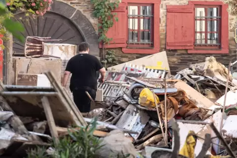 Ein Anwohner zwischen Unrat und aufgetürmten Einrichtungsgegenständen in der Innenstadt von Ahrweiler. 