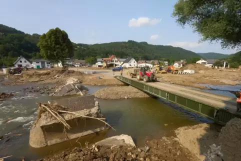 Ein Traktor fährt über eine Behelfsbrücke in der Gemeinde Insul im Ahrtal.