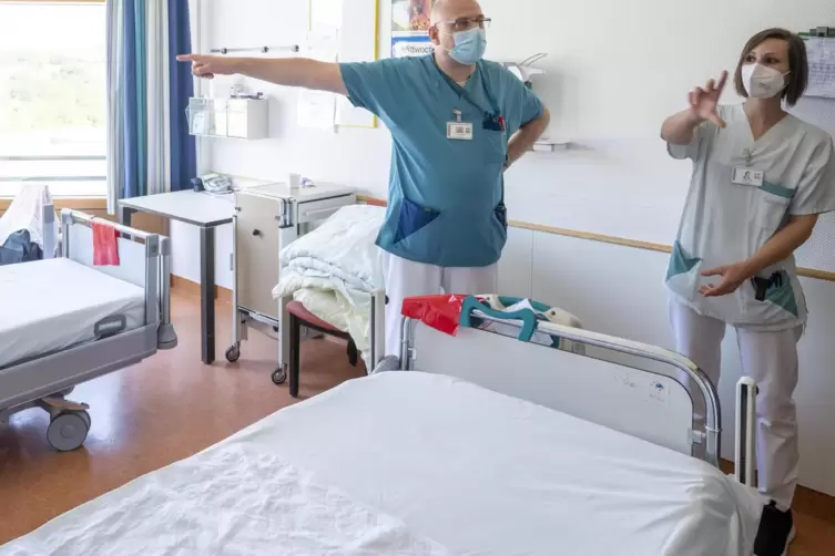 Chefarzt Heiko Bittmann und die stellvertretende Stationsleiterin Sarah Eicher zeigen eines der Frühreha-Zimmer. 