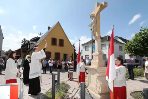 Das 200 Jahre alte Kreuz, das dem Platz seinen Namen gibt und an dessen Spitze steht, wird neu gesegnet. 