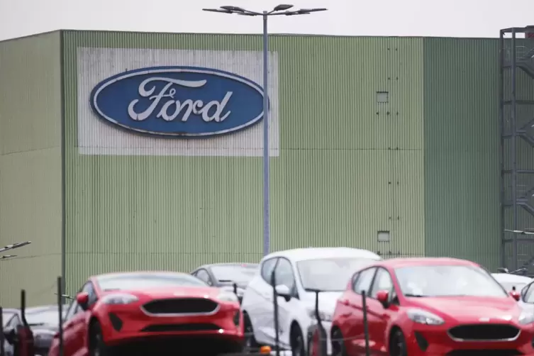 Neu gebaute Autos stehen auf Lastwagen vor dem Ford Werk in Köln.