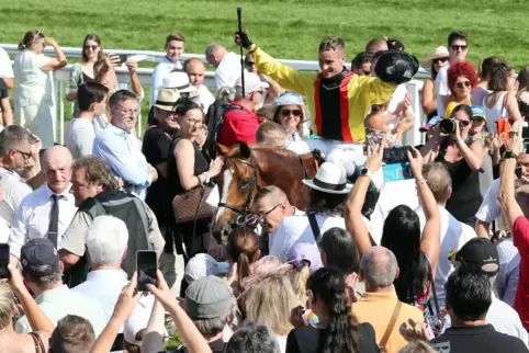 Umringtes Siegergespann: René Piechulek mit Torquator Tasso nach dem Triumph in Iffezheim. 