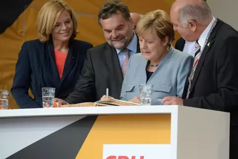 2017: Angela Merkel trägt sich am Rande eines Wahlkampftermins ins Goldene Buch der Stadt ein.