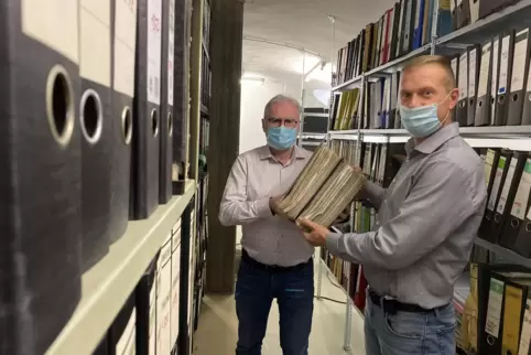  Büroleiter Joachim Meyer und Johannes Kajukin von der Bauabteilung im Archiv des Grünstadter Rathauses. 