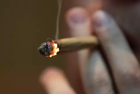 Ein Mann raucht einen Joint mit Marihuana.