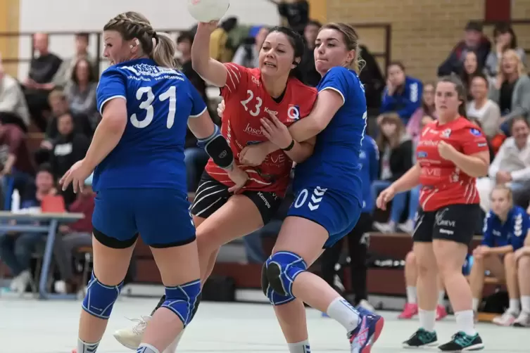 Ex-Torhüterin Susie Dausch zwängt sich zwischen die HSG-Spielerinnen Tamara Bentz (Nummer 31) und Vanessa Galow. Rechts hinten d