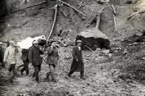 Ein Foto, das auch nach 90 Jahren den Schrecken widerspiegelt: Männer tragen eine Leiche aus den Trümmern. Die beiden vorderen T