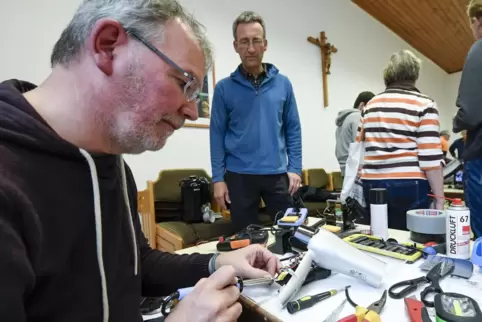 Technisch versiert: Joachim Hartmüller (links) repariert einen Föhn beim Repair-Café in Dirmstein. 