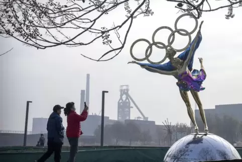 Am 4. Februar beginnen die Winterspiele von Peking. Im Bild: Besucher fotografieren eine Statue von Eiskunstläufern mit den olym
