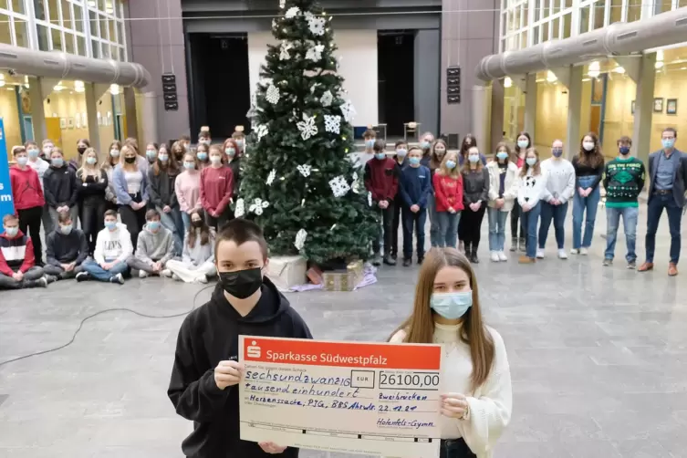  Marcel Mang aus der 10a und Lara Stephan aus der 9a präsentierenden Spendenscheck, ganz rechts steht Schulleiter Jörg Neurohr. 