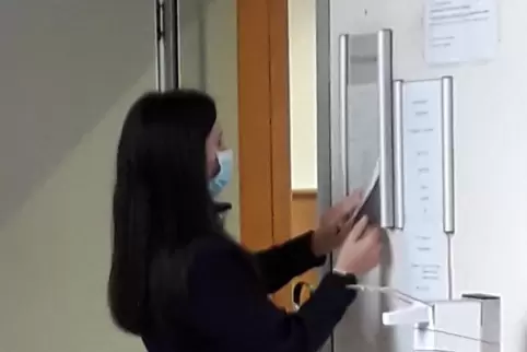 Eine Gerichtsdienerin befestigt an der Tür zu Saal 1 des Landgerichts einen Zettel, der die nächsten Verhandlungstage im Roth-Pr