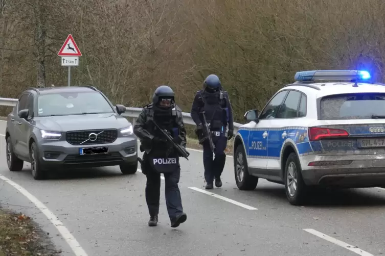 Schwer bewaffnete Polizisten sichern den Tatort ab. 