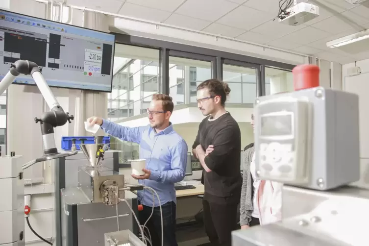 Laboringenieur Harald Wehner und ein Studierender am Extruder im neuen Kunststofflabor. 