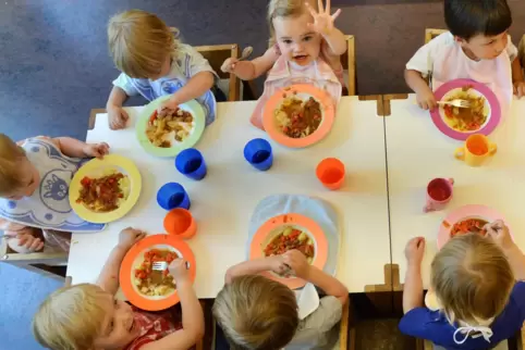 Diese Kita-Kinder haben beim fröhlichen Mittagessen sichtlich Spaß.