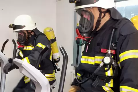 Schweißtreibend: Achim und Lukas Blazek strampeln in voller Montur auf Ergometern, die in der Atemschutzanlage der Feuerwehren d