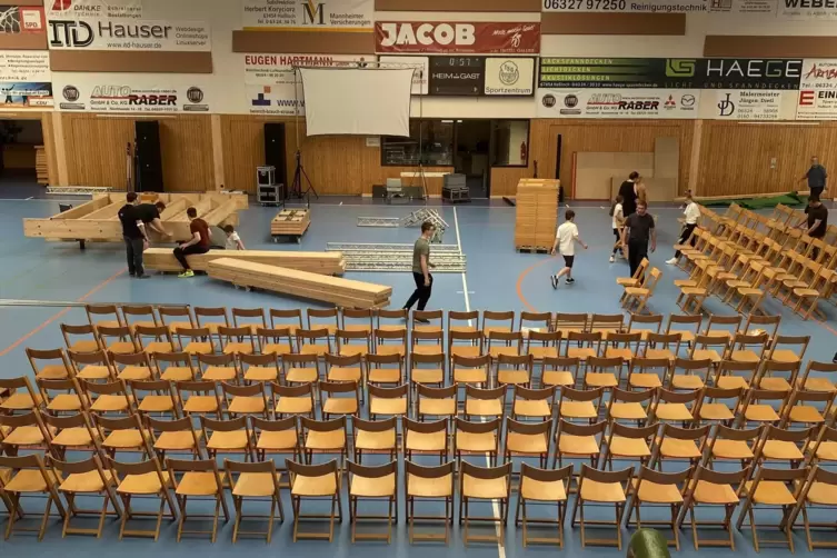 Die Stühle stehen im TSG-Sportzentrum. Die Bühne wird noch aufgebaut . 