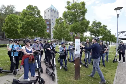 Kurze Pause an einer Stele am Rheinufer: Im Hintergrund die Walzmühle. 