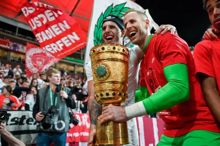  Leipzigs Dominik Szoboszlai und Torhüter Péter Gulásci (rechts) jubeln mit dem DFB-Pokal.