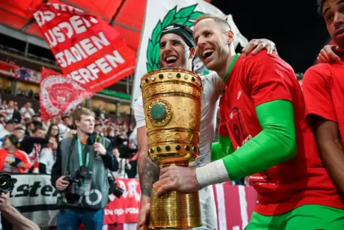  Leipzigs Dominik Szoboszlai und Torhüter Péter Gulásci (rechts) jubeln mit dem DFB-Pokal.