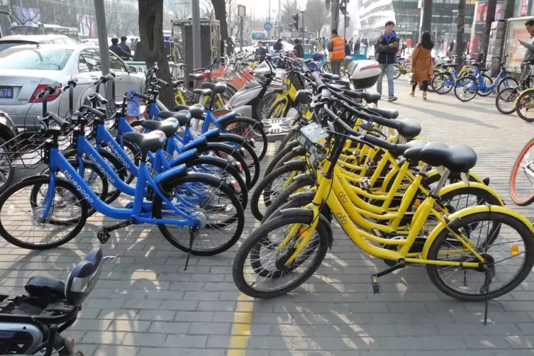 Leihräder stehen neben einer Straße in Peking. 