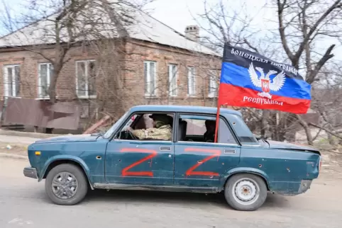 Besatzer fahren mit der Fahne der „Volksrepublik“ Donezk durch das eroberte Mariupol.
