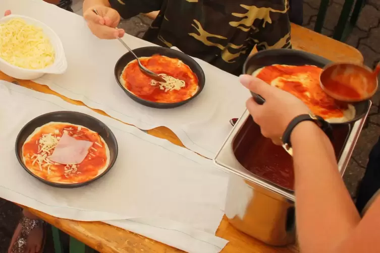 Für Kinder wird kostenloses Pizzabacken mit Mini-Blechen angeboten. 