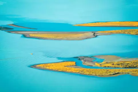 Wildnis in Schwedisch-Lappland: zerklüftete Landschaft und ein pastellblauer Gletscherfluss im Sonnenlicht.