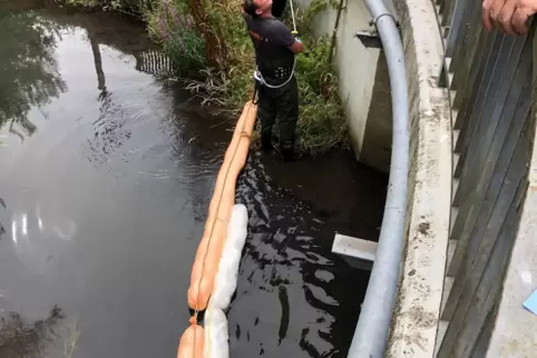  Feuerwehrmänner entnehmen Proben im Rohrbach.