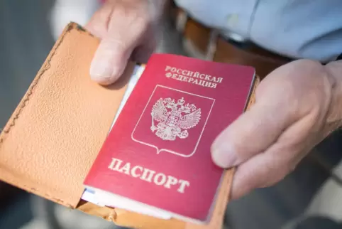 In der estnischen Stadt Narva am Grenzübergang nach Russland hält ein Mann seinen russischen Pass in den Händen.