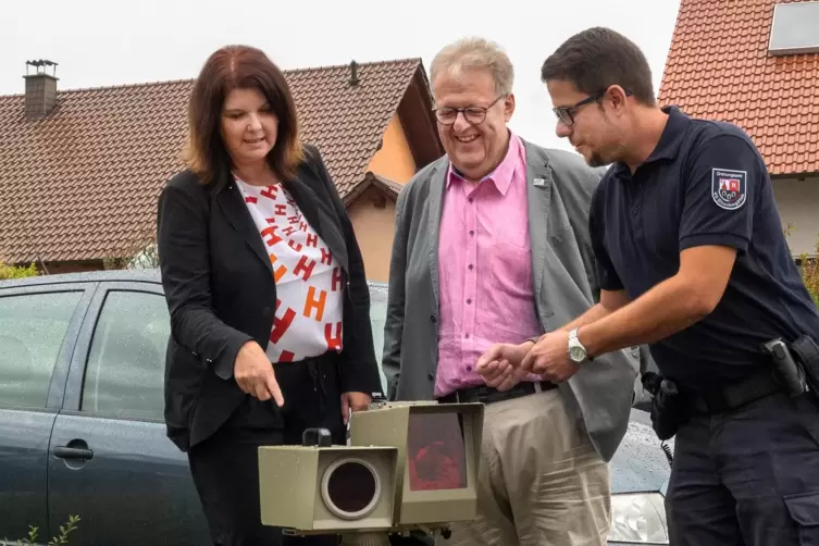 Die Bürgermeister Sabine Wienpahl und Bernd Frey lassen sich die Blitzanlage von Dennis Kandziora (rechts) vom Eisenberger Ordnu